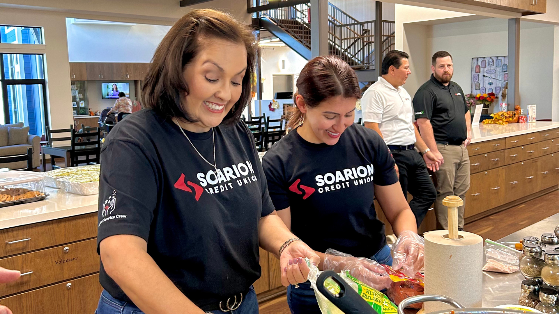 Employee smiles as they prepare a meal at a local charity