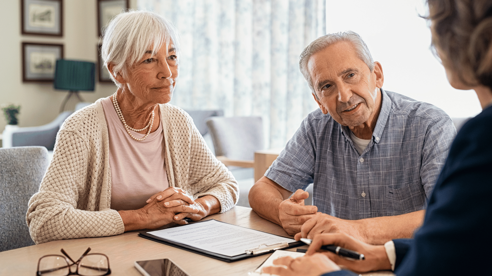 elderly man and woman receiving financial advice and assistance at a table
