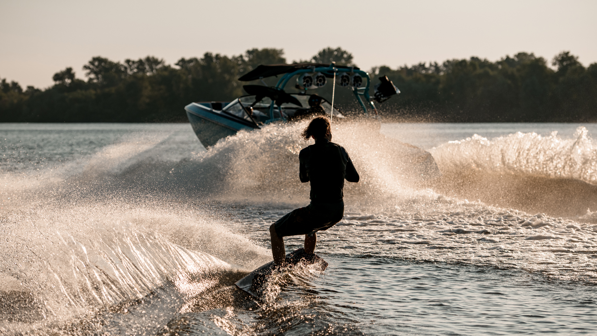 Man on waterboard having fun being pulled by boat on water